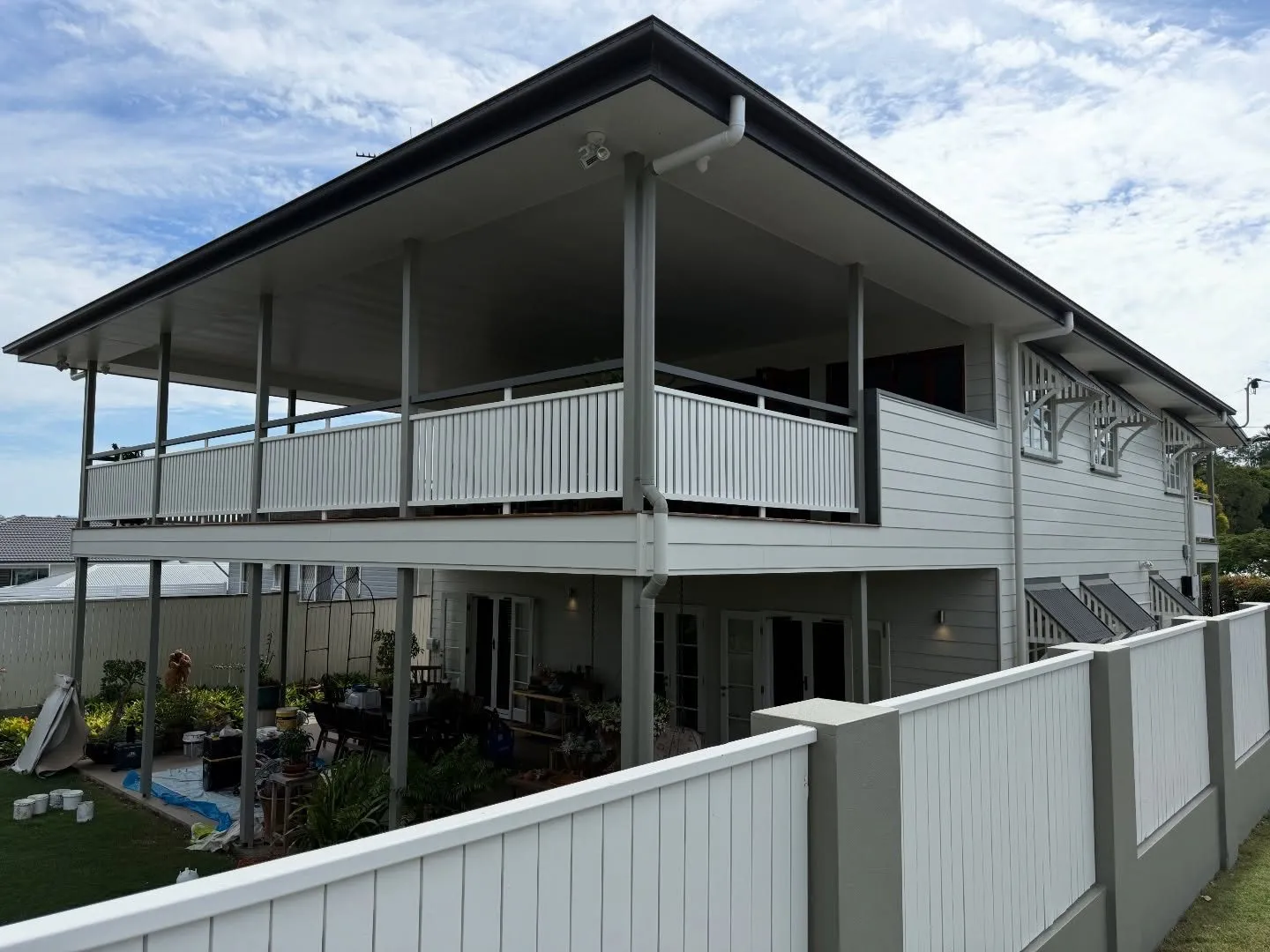 Highset Queenslander in Stafford repainted white with white verandah balustrades